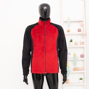 May include: A red and black fleece jacket with a full-length zipper. The jacket has a high collar and long sleeves. The mannequin is wearing black pants and gloves. The jacket is displayed in front of a white background.