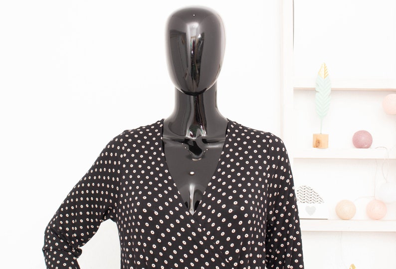 May include: A black and white polka dot long-sleeved dress with a V-neckline.