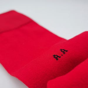 May include: Red socks with black lettering that says "A.P."