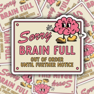 May include: A sticker with a cartoon brain character saying "Sorry Brain Full, Out of Order Until Further Notice". The brain is pink and has a yellow smile. The sticker is white with a pink and yellow border.