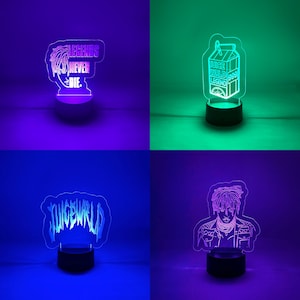 May include: Four LED night lights with different designs. One reads "LEGENDS NEVER DIE." Another features a milk carton with "JUICE WRLD LEGEND 999." The third says "JUICEWRLD," and the last is a portrait of a person.