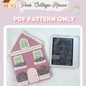 May include: A pink crocheted house-shaped e-reader cover with green windows and white trim. The cover is decorated with small crocheted flowers. The text "PDF PATTERN ONLY" is displayed in white letters on a pink background.