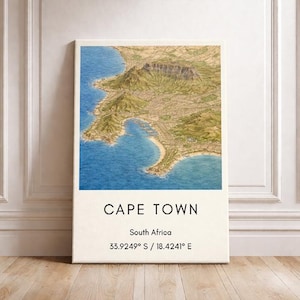 Könnte beinhalten: Gerahmter Leinwanddruck von Kapstadt, Südafrika, mit einer detaillierten topografischen Karte in Grün-, Beige- und Blautönen. Der Name der Stadt und die Koordinaten sind in Schwarz auf Weiß gedruckt.