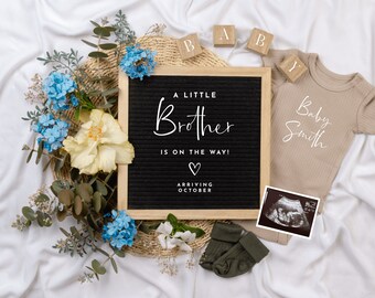 May include: A black letter board with the text "A Little Brother Is On The Way!" and a heart symbol. The board is surrounded by flowers, a baby onesie, and a sonogram image.