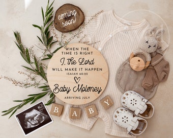 May include: A wooden sign with the text "WHEN THE TIME IS RIGHT I. the Lord WILL MAKE IT HAPPEN ISAIAH 60:22" and a heart symbol. Below the text is "Baby Moloney ARRIVING JULY". There are wooden blocks that spell out "BABY" and a black and white ultrasound image.