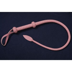 May include: A pink leather whip with a braided handle and a pointed tip.