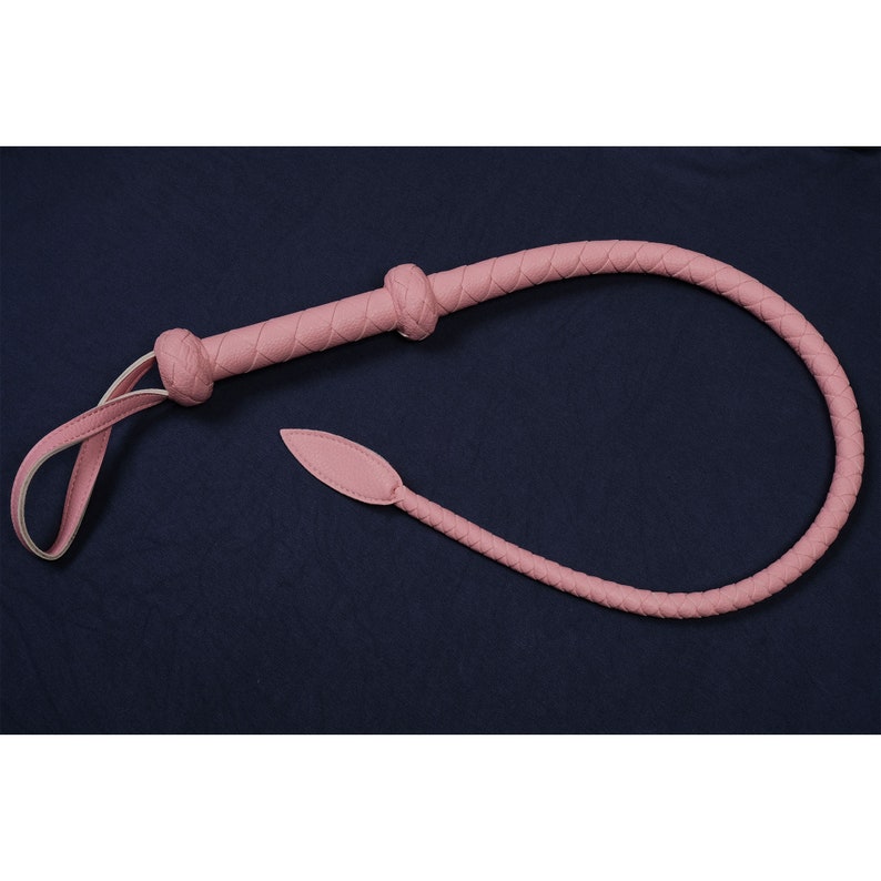 May include: A pink leather whip with a braided handle and a pointed tip.