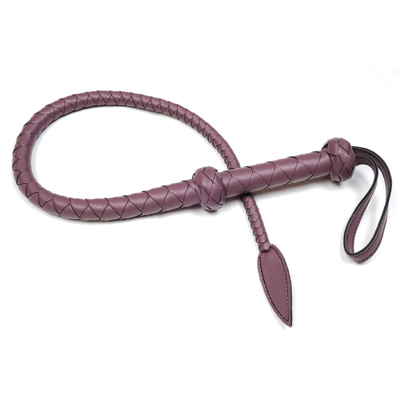May include: A purple leather braided whip with a knotted handle and a long, pointed tassel.