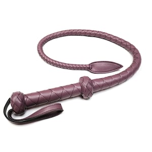 May include: A purple leather whip with a braided handle and a loop at the end.
