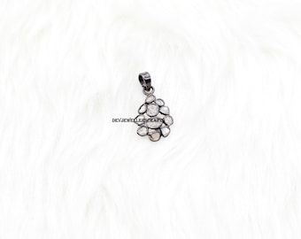 Peut inclure: Un pendentif en argent avec un groupe de petits diamants blancs bruts sertis en forme de larme. Le pendentif est sur un fond blanc.