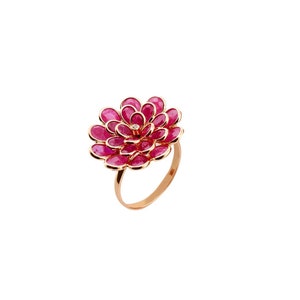 May include: A gold ring with a pink flower design made of ruby stones. The center of the flower has a single diamond.