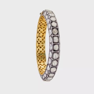 Pode incluir: Um bracelete de ouro com uma banda de prata cravejada de pequenos diamantes redondos. Os diamantes estão cravejados em um padrão geométrico.