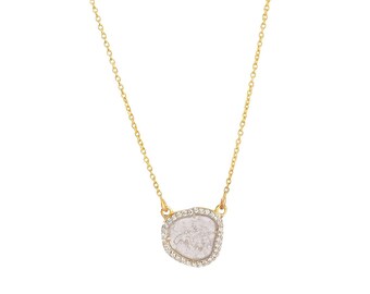 Puede incluir: Un collar de cadena de oro con un gran colgante de diamante transparente de forma irregular rodeado por un halo de diamantes más pequeños.