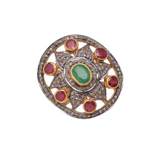Könnte beinhalten: Ein Silber- und Goldring mit einem grünen ovalen Edelstein, der von kleineren roten Edelsteinen und weißen Diamanten umgeben ist. Der Ring hat ein florales Design.