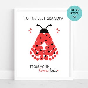 Op de afbeelding: Een ingelijste print met de tekst "TO THE BEST GRANDPA" en "FROM YOUR love bug". Het kunstwerk toont een rood lieveheersbeestje-ontwerp gemaakt van vingerafdrukken, met zwarte stippen en antennes. Kleine rode hartjes zijn verspreid.