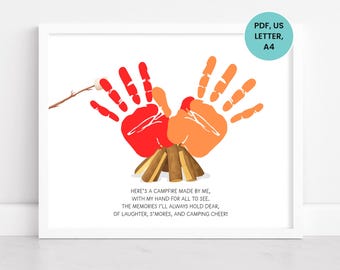 May include: A framed print featuring handprint art in red and orange, depicting a campfire scene. The artwork includes a marshmallow on a stick and text that reads, "Here's a campfire made by me..." The print is designed for US Letter and A4 paper sizes.