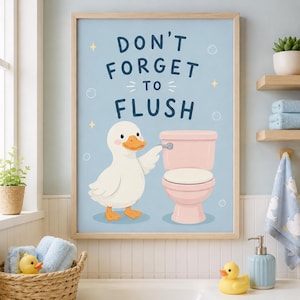 May include: A framed wall art print with a light blue background featuring a white duck standing next to a pink toilet. The text DON'T FORGET TO FLUSH is printed in dark blue letters above the duck. Small yellow stars and white circles decorate the print.