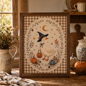 May include: A framed cross-stitch embroidery featuring a white goose wearing a black witch hat and a blue bow, holding a jack-o'-lantern bucket. The design includes orange pumpkins, a crescent moon, stars, and autumn foliage, all set against a brown gingham background.