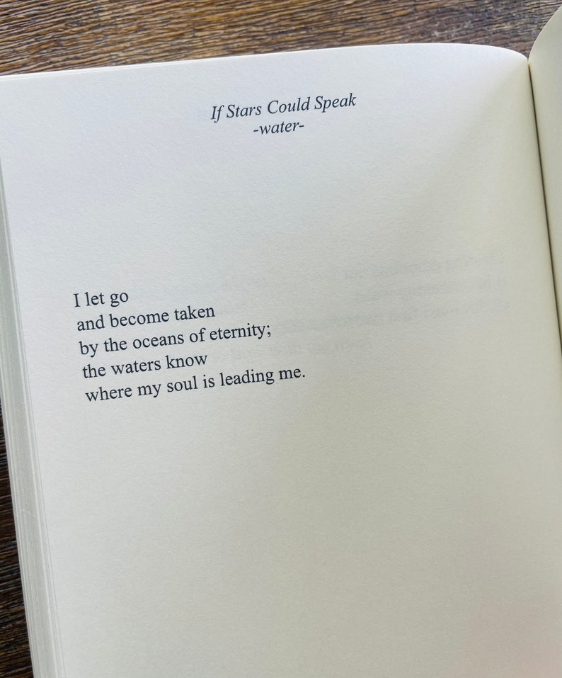 以下が含まれることがあります： 「If Stars Could Speak -water-」というタイトルの詩が書かれた開いた本。詩はページの中央に配置され、最初の行は「I let go」です。紙はオフホワイトで、テキストはシンプルで読みやすいフォントです。