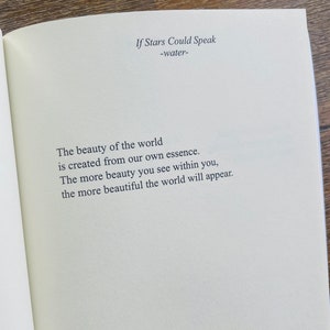 以下が含まれることがあります： クリーム色のページにテキストが書かれた開いた本。タイトル「If Stars Could Speak」とサブタイトル「-water-」が上部にあります。下のテキストは「世界の美しさは私たち自身の本質から生まれます。あなた自身の中に美しさを見れば見るほど、世界はより美しく現れます。」と書かれています。