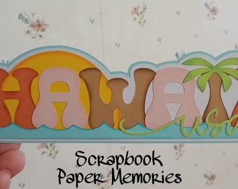 May include: A colorful paper craft with the word "HAWAII USA" in a layered, 3D style. The letters are in shades of orange, pink, brown, and yellow, with a blue wave and a green palm tree.