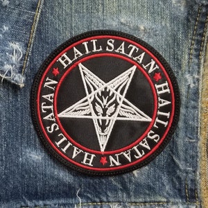 May include: A denim vest with a black and white patch featuring a pentagram and the words "Hail Satan" repeated around the perimeter.