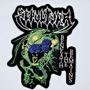 Puede incluir: Parche negro bordado con el nombre de la banda "SEPULCHRAL" en letras blancas estilizadas. Presenta un diseño de calavera verde y azul con rosas azules y el texto "BENEATH REMAINS".