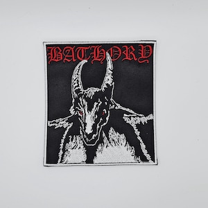 May include: Black and white embroidered patch featuring a horned demon with red eyes. The word "BATHORY" is embroidered in red gothic lettering across the top of the patch. The patch is square with a white border.
