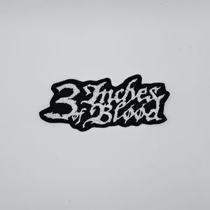 Könnte beinhalten: Ein schwarz-weiß gestickter Aufnäher mit dem Text "3 Inches of Blood" in einer stilisierten Schriftart. Der Aufnäher hat einen schwarzen Rand und ist vor einem weißen Hintergrund platziert.