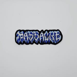 May include: Embroidered patch with the word "BASTARD" in stylized blue and white lettering. The patch has a black border and is set against a white background. The design has a heavy metal or punk rock aesthetic.