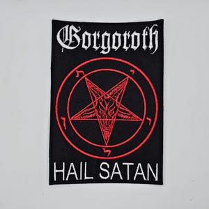 May include: Black rectangular patch featuring the word "Gorgoroth" in white gothic lettering above a red pentagram within a red circle. The words "HAIL SATAN" are in white lettering below.