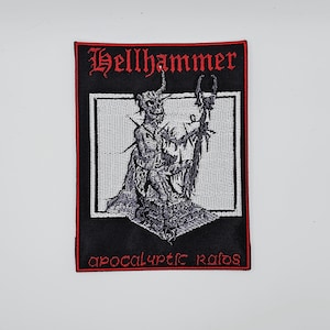 Puede incluir: Parche negro con borde rojo. Presenta la palabra "Hellhammer" en letras góticas rojas. El parche tiene un fondo blanco con una detallada ilustración en negro y gris de una figura demoníaca. El texto "apocalyptic raids" está en la parte inferior.