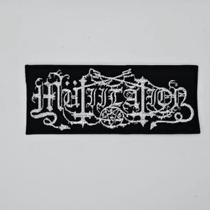 May include: Black rectangular patch with white embroidered text that reads "Mutilation" in a gothic font. The patch features a pentagram and other decorative elements. The patch is likely for a jacket or bag.