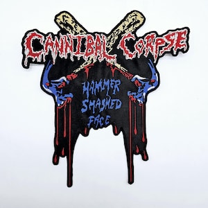 以下が含まれることがあります： 赤と黒で「Cannibal Corpse」のバンド名と青で「Hammer Smashed Face」の文字が刺繍されたパッチ。デザインには、交差した野球のバットと様式化されたスカルが含まれています。