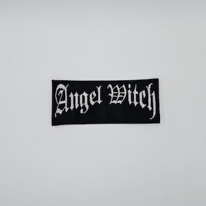 Può includere: Toppa rettangolare nera con la scritta "Angel Witch" ricamata in bianco con caratteri gotici. Adatta per abbigliamento o accessori.