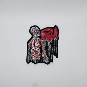 Könnte beinhalten: Gestickter Aufnäher mit einer skelettartigen Figur mit freiliegenden Organen und einem roten, tropfenden Design. Der Aufnäher hat einen schwarzen Rand und das Wort "DEATH" in Rot. Das Design ist detailliert und hat ein gotisches Thema.