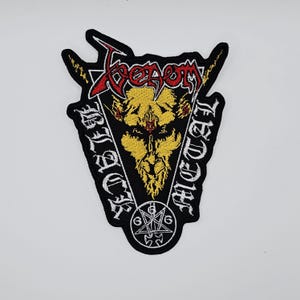 May include: Black patch with the word "Venom" in red and yellow, above a yellow and black illustration of a horned figure. The words "Black Metal" are on either side of the figure. A pentagram with the numbers 6 is at the bottom.