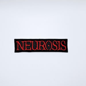 May include: A black rectangular patch featuring the word "NEUROSIS" in red, gothic lettering. The patch has a black border and is set against a white backdrop. The text is bold and clearly visible.