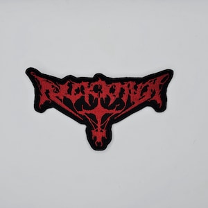 Può includere: Toppa ricamata con un design gotico rosso su un bordo nero. La toppa presenta un motivo intricato e simmetrico, con un emblema centrale che assomiglia a un volto o una maschera stilizzata. Per abbigliamento o accessori.