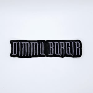 Peut inclure: Écusson brodé noir avec le texte "DIMMU BORGIR" en lettres gothiques grises. L'écusson est rectangulaire et bordé de noir. Le texte est centré sur l'écusson.