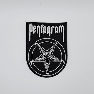 Pode incluir: Patch preto com a palavra "Pentagram" em letras brancas estilizadas. O patch apresenta um pentagrama branco com uma cabeça de cabra dentro de um círculo. O patch tem formato de escudo.