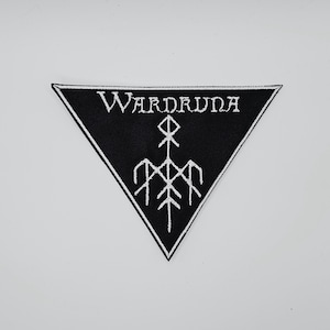 May include: Black triangular patch with white embroidered text and a stylized symbol. The text reads "WARDRUNA" in a gothic font. The symbol is a combination of lines and shapes, resembling a tree or a figure.