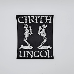 Puede incluir: Parche cuadrado negro con texto e imágenes bordadas en blanco. El texto dice "CIRITH UNGOL" arriba y debajo de dos figuras de esqueleto arrodilladas con las manos levantadas. El parche tiene un borde negro, para ropa o accesorios.