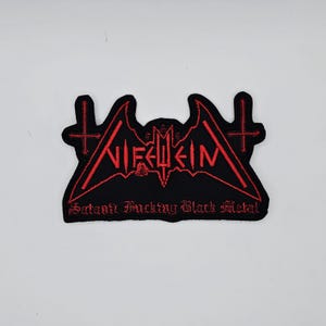 May include: Black embroidered patch with red text and a bat-like design. The patch features the word "NIFELHEIM" in a stylized font, with the text "Satanic Fucking Black Metal" below. Two crosses are on either side.