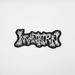 May include: Black embroidered patch with the word "INCANTATION" in white, stylized, gothic lettering. The patch has a black border and a white, tree-like design within the letters. The patch is likely for clothing or accessories.