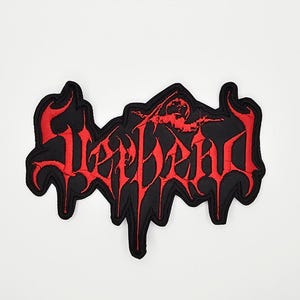May include: Black and red embroidered patch with the word "SLAYDEAD" in a gothic font. The patch features a stylized figure above the text. The patch has a black border and is likely designed to be sewn or ironed onto clothing or accessories.