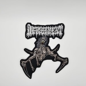 May include: Black embroidered patch featuring the word "DEHUMANIZED" in white above a detailed illustration of a skeletal creature with outstretched arms. The creature is in shades of gray and brown.