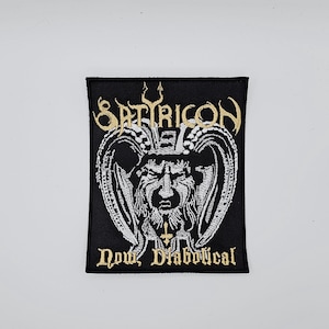 May include: Black embroidered patch with gold lettering reading "SATYRICON" above a detailed white and black illustration of a horned figure. The text "Now, Diabolical" is below the illustration, also in gold.