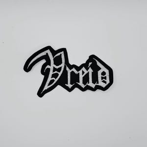 Può includere: Toppa ricamata in bianco e nero con la parola "Dreid" in carattere gotico. La toppa ha uno sfondo nero con cuciture bianche per le lettere e il bordo. Adatta per abbigliamento o accessori.