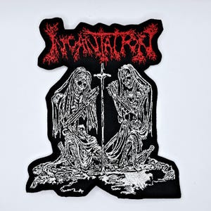 May include: Black embroidered patch featuring the word "INCANTATION" in red above a detailed white illustration. The illustration depicts two skeletal figures kneeling, with a cross between them. The patch has a black border.